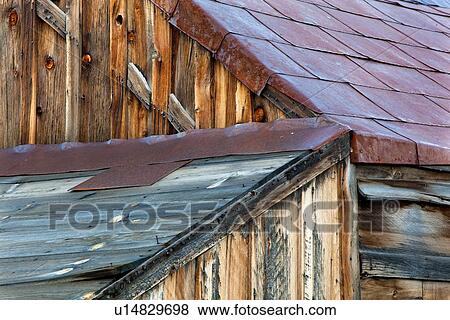 Stock Photo - Detail of original wooden housing, wooden plank walls, and red metal tiled roof, Bodie pioneer village, California. Fotosearch