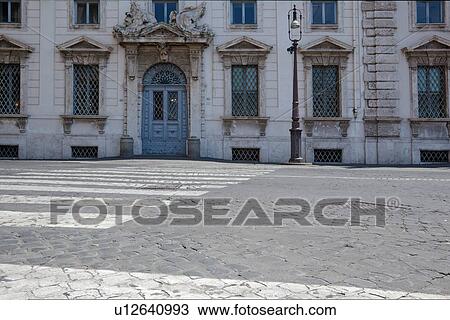 Stock Image - Detail of Piazza Quirinale showing cobblestone road, pedestian crossing and Baroque architecture of palace. Fotosearch