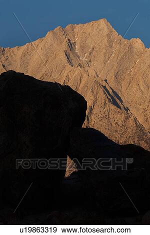 Stock Photo - Detail of Sierra Nevada mountains at dawn, with shadow geometric abstract formation, against mountain, blue sky above.. Fotosearch