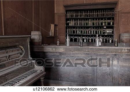 Drinking saloon as seen from inside with piano, and beer bottles behind bar, desaturated image, Bodie pioneer village, California View Large Photo Image Stock Image - Drinking saloon as seen from inside with piano, and beer bottles behind bar, desaturated image, Bodie pioneer village, California. Fotosearch