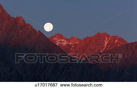 Full moon setting over snow-tipped High Sierras mountains, with red light of dawn lighting the range View Large Photo Image Stock Photo - Full moon setting over snow-tipped High Sierras mountains, with red light of dawn lighting the range. Fotosearch