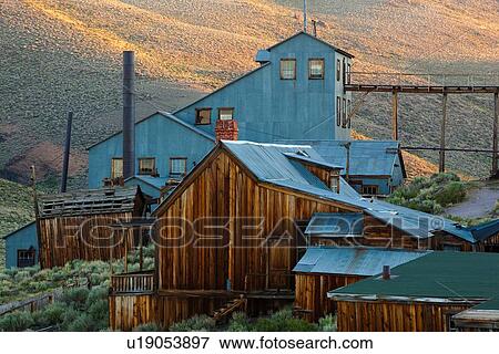 Stock Photo - Group of original wooden mining buildings, housing with blue walls and roof, and bridge at dawn, with wild sage, Bodie pioneer village, California. Fotosearch