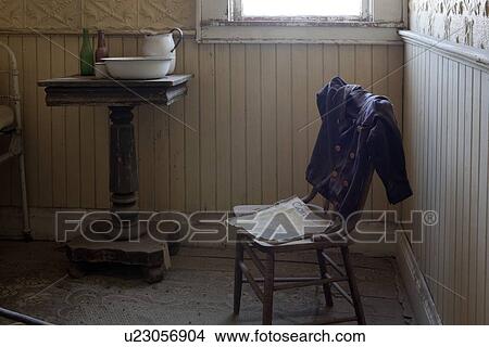 Picture - Hotel guest room with washstand, chair and clothing draped over, desaturated image, Bodie pioneer village, California. Fotosearch