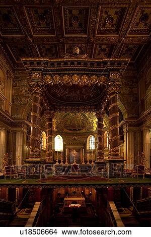 Picture - Interior of Santa Maria Maggiore, Rome, showing central nave, baldacchino over altar, coffered ceiling, rich Baroque decoration, and crypt below. Fotosearch