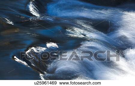 Stock Photo - Motion blur of creek water over rocks, Sierra Nevada. Fotosearch