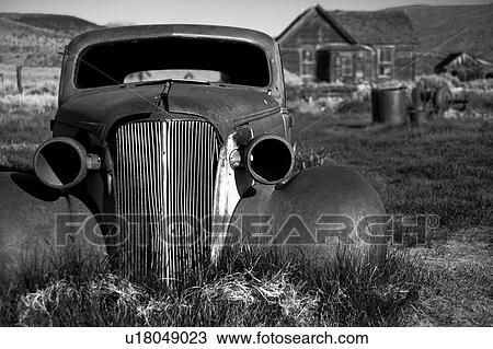 Old car abandoned in field, front view, with wooden house and hills beyond, desaturated image, Bodie pioneer village, California View Large Photo Image Stock Image - Old car abandoned in field, front view, with wooden house and hills beyond, desaturated image, Bodie pioneer village, California. Fotosearch