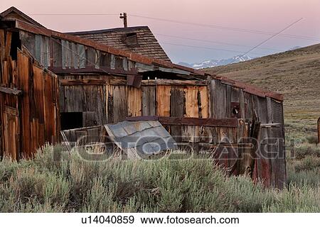 Old wooden house at dawn, with Sierra Nevada snow-tipped mountain range in distance, pink sky, sage brush foreground, Bodie pioneer village, California View Large Photo Image Stock Photo - Old wooden house at dawn, with Sierra Nevada snow-tipped mountain range in distance, pink sky, sage brush foreground, Bodie pioneer village, California. Fotosearch