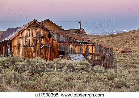 Old wooden houses at dawn, with Sierra Nevada snow-tipped mountain range in distance, pink sky, sage brush foreground, Bodie pioneer village, California View Large Photo Image Stock Photography - Old wooden houses at dawn, with Sierra Nevada snow-tipped mountain range in distance, pink sky, sage brush foreground, Bodie pioneer village, California. Fotosearch