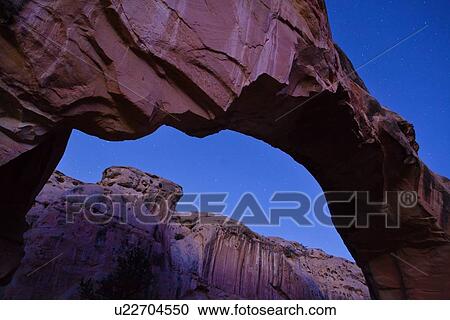 Panorama of Hickman Bridge, Utah in dawn light, with indigo starlit sky, and distant mountains seen through arch View Large Photo Image Stock Image - Panorama of Hickman Bridge, Utah in dawn light, with indigo starlit sky, and distant mountains seen through arch. Fotosearch