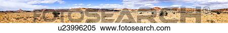 Stock Photography - Panorama view (multiple stitched images) of Family Butte, with foreground single green shrub, and expanse of rock formations beyond, blue sky, fluffy white clouds, on lovely fall afternoon, Utah. Fotosearch
