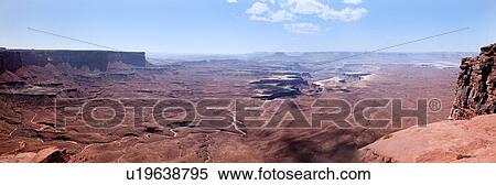 Stock Photography - Panorama view of Green River Overlook, stretching miles to deep winding crevice in valley, sunny fall morning, with blue sky and puffy cloud formation, Utah. Fotosearch