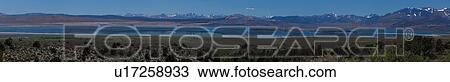 Stock Image - Panorama view of Mono Lake, morning summer sun with snow-capped mountain range reflected in water. Fotosearch