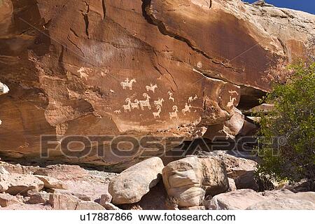 Stock Photograph - Petroglyphs etched into red rock, Arches National Park, Utah. Fotosearch