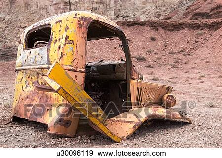Stock Photo - Rusted hulk of antique yellow car abandoned in Reds Canyon, Utah, partially desaturated image. Fotosearch