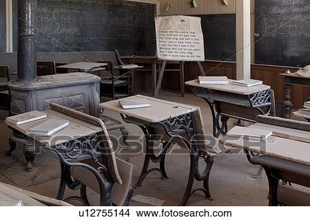 Picture - Schoolroom with original old desks and chairs, chalkboard, desaturated image, Bodie pioneer village, California. Fotosearch