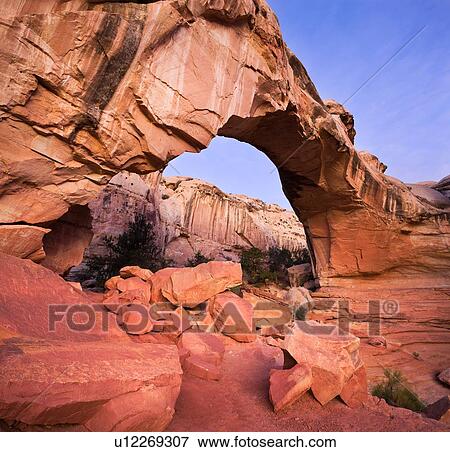 Stitched view of Hickman Bridge, Utah, in early dawn light, pink rock against blue sky and pink clouds, with distant mountains seen through arch View Large Photo Image Stock Photo - Stitched view of Hickman Bridge, Utah, in early dawn light, pink rock against blue sky and pink clouds, with distant mountains seen through arch. Fotosearch