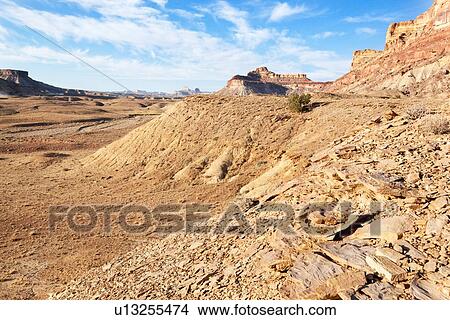 Picture - View of Bottleneck Mountain, San Rafael Swell on sunny fall morning with blue sky and puffy white clouds, track winding along rocky ridge, Buckhorn Draw, Utah. Fotosearch