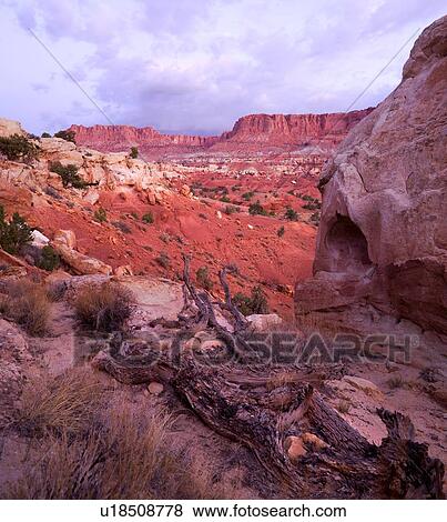 View of rocky red landscape of valley in early morning light with blue sky lit with fluffy grey clouds, Utah View Large Photo Image Stock Photo - View of rocky red landscape of valley in early morning light with blue sky lit with fluffy grey clouds, Utah. Fotosearch