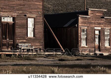 Stock Photo - Wooden buildngs on main street, facades lit in dawn light, desaturated image, Bodie pioneer village, California. Fotosearch
