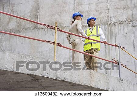 Stock Image - Architect and construction manager on site. Fotosearch