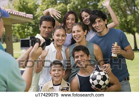 Boy (13-15) with family and friends, posing for video camera. View Large Photo Image Stock Photography - Boy (13-15) with family and friends, posing for video camera.. Fotosearch