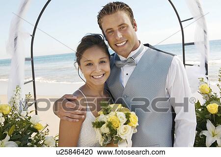 Bride and Groom under archway on beach, (portrait) View Large Photo Image Stock Image - Bride and Groom under archway on beach, (portrait). Fotosearch