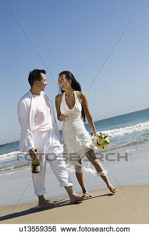 Bride and Groom walking on beach View Large Photo Image Stock Photograph - Bride and Groom walking on beach. Fotosearch