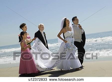 Bride and Groom walking with family on beach View Large Photo Image Stock Image - Bride and Groom walking with family on beach. Fotosearch