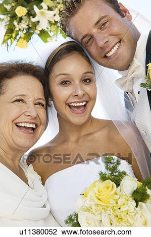 Stock Image - Bride and Groom with mother outdoors, (close-up), (portrait). Fotosearch