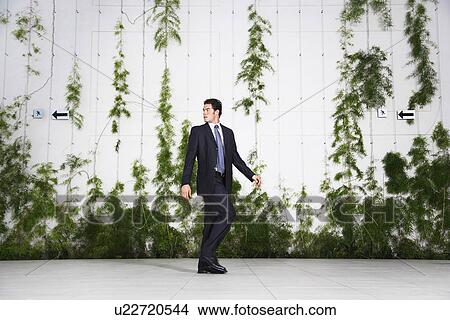 Picture - Businessman looking over shoulder, outdoors. Fotosearch