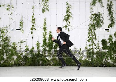 Stock Image - Businessman running, outdoors. Fotosearch