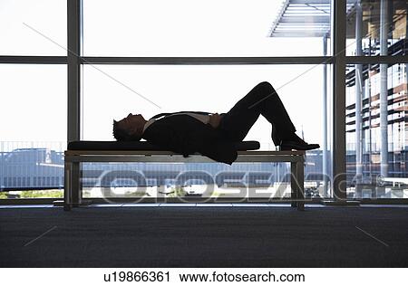 Businessman sleeping on bench in office building View Large Photo Image Stock Image - Businessman sleeping on bench in office building. Fotosearch