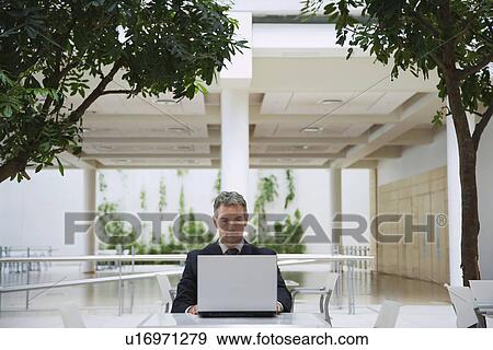 Stock Photo - Businessman using laptop, outdoors. Fotosearch