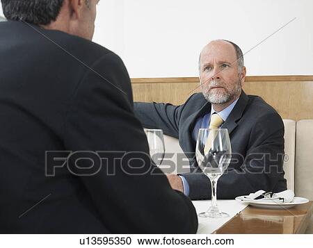 Stock Image - Businessmen in restaurant. Fotosearch