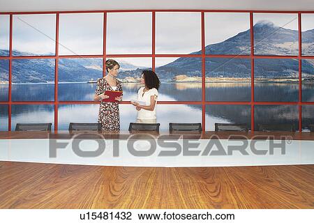 Businesswomen standing, Talking in modern Conference Room View Large Photo Image Stock Image - Businesswomen standing, Talking in modern Conference Room. Fotosearch