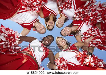 Stock Image - Cheerleaders in Huddle, view from below, (view from below). Fotosearch