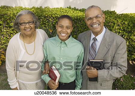 Christian Grandparents and Grandson in garden holding Bibles, portrait View Large Photo Image Stock Photograph - Christian Grandparents and Grandson in garden holding Bibles, portrait. Fotosearch