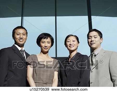 Stock Photo - Confident Businesspeople group portrait, low angle view. Fotosearch