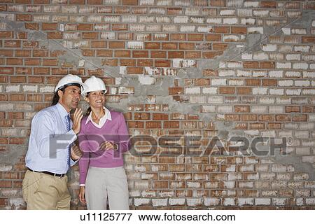 Construction manager and architect talking on site View Large Photo Image Stock Photo - Construction manager and architect talking on site. Fotosearch
