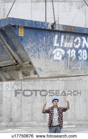 Stock Photograph - Construction worker directing movement of skip. Fotosearch