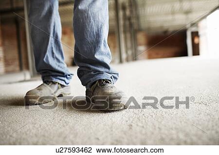 Stock Image - Construction Worker on building site, low section. Fotosearch