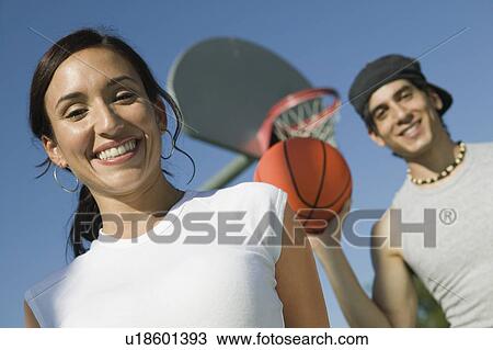 Stock Image - Couple at Basketball Court, low angle view.. Fotosearch