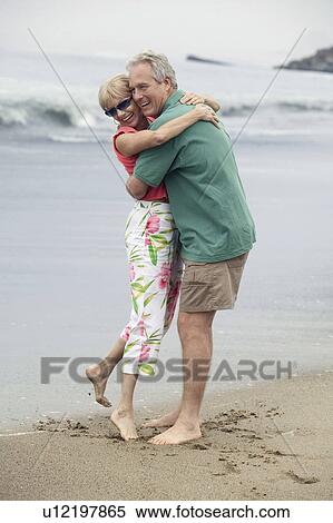 Stock Photography - Couple embracing on beach. Fotosearch