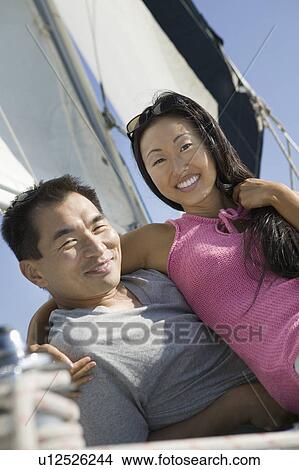 Picture - Couple embracing on sailboat, (portrait). Fotosearch