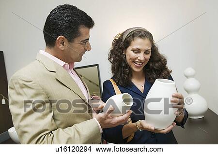 Picture - Couple Examining Vases in furniture shop. Fotosearch