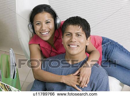 Stock Photograph - Couple Listening to Music and Reading, portrait. Fotosearch