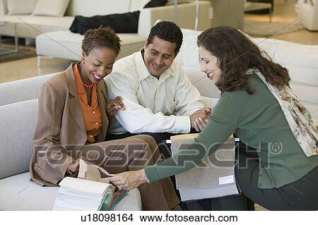 Couple Looking at fabric Swatches With Saleswoman in furniture store View Large Photo Image Picture - Couple Looking at fabric Swatches With Saleswoman in furniture store. Fotosearch