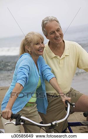 Couple on bicycles at beach View Large Photo Image Stock Photo - Couple on bicycles at beach. Fotosearch