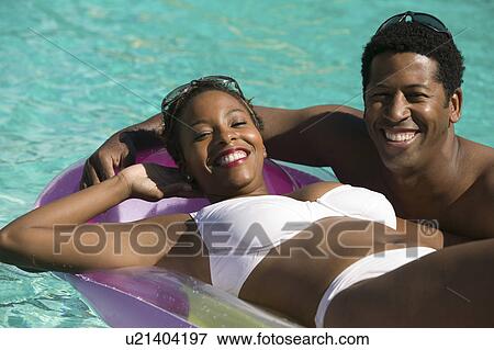 Stock Photo - Couple Relaxing in Swimming Pool, portrait.. Fotosearch