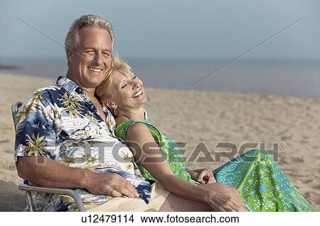 Picture - Couple relaxing on beach. Fotosearch